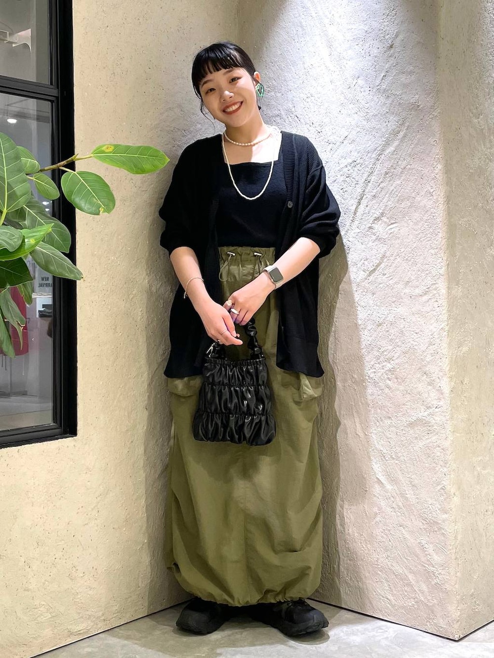 ブラック系のタンクトップ、ブラック系のカーディガン/ボレロ、ブラック系のショルダーバッグを着用したレディースの夏コーディネートの2枚目の写真