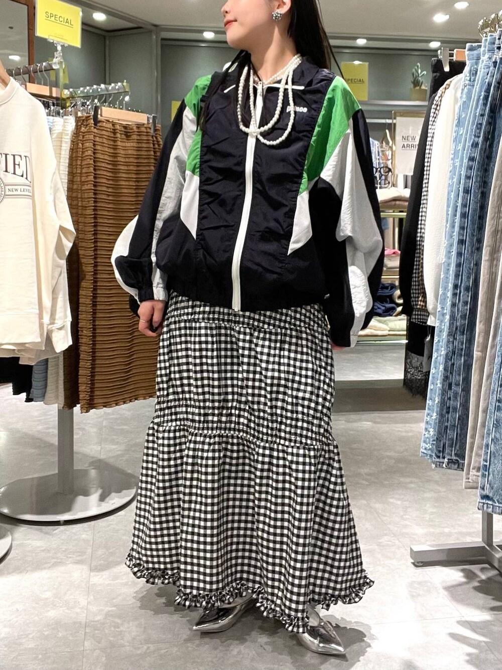 シルバー系のパンプス、ブルー系のブルゾン、ブラック系のバックパック/リュックを着用したレディースの春コーディネートの2枚目の写真