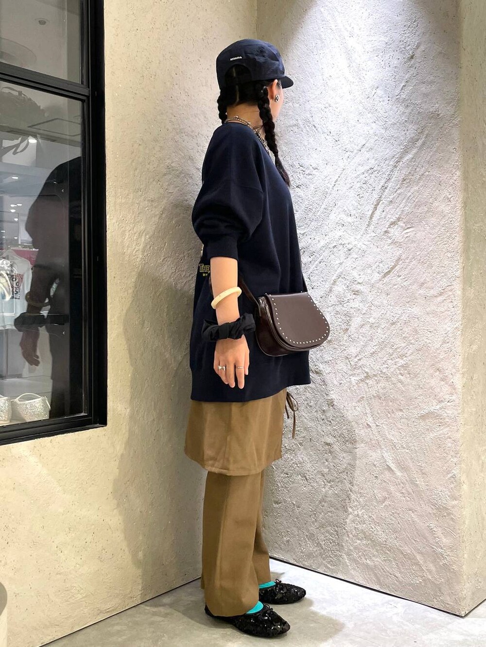 ブラウン系のショルダーバッグ、ブルー系のスウェット、ブラック系のバレエシューズを着用したレディースの秋コーディネートの4枚目の写真