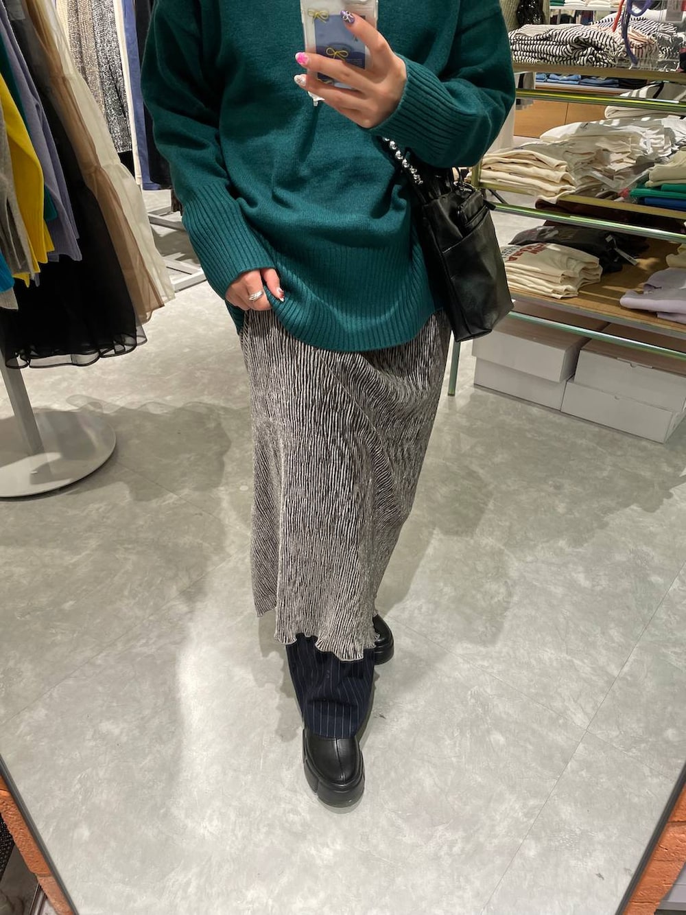 ブラック系のブーツ、ブルー系のその他パンツ、グリーン系のニット/セーターを着用したレディースの冬コーディネートの4枚目の写真