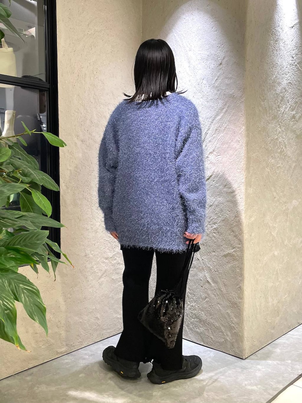 ブラック系のハンドバッグ、ホワイト系のTシャツ/カットソー、ブラック系のつなぎ/オールインワンを着用したレディースの冬コーディネートの3枚目の写真