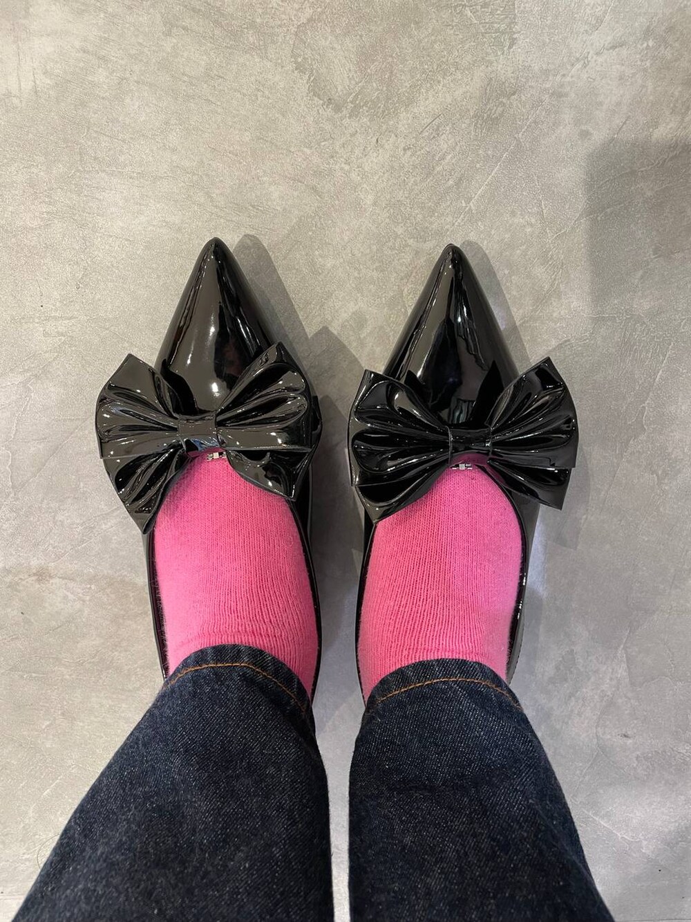 ブラック系のハンドバッグ、ブルー系のデニムパンツ、ブラック系のパンプスを着用したレディースの春コーディネートの8枚目の写真