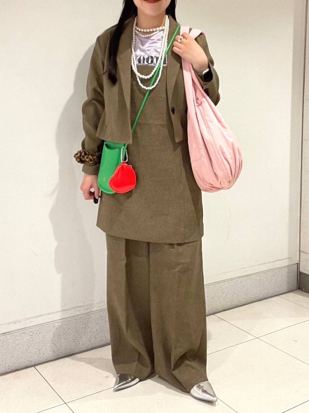 ブラウン系のスラックス、ブラウン系のテーラードジャケット、ブラウン系のキャミソールを着用したレディースの春コーディネートの2枚目の写真