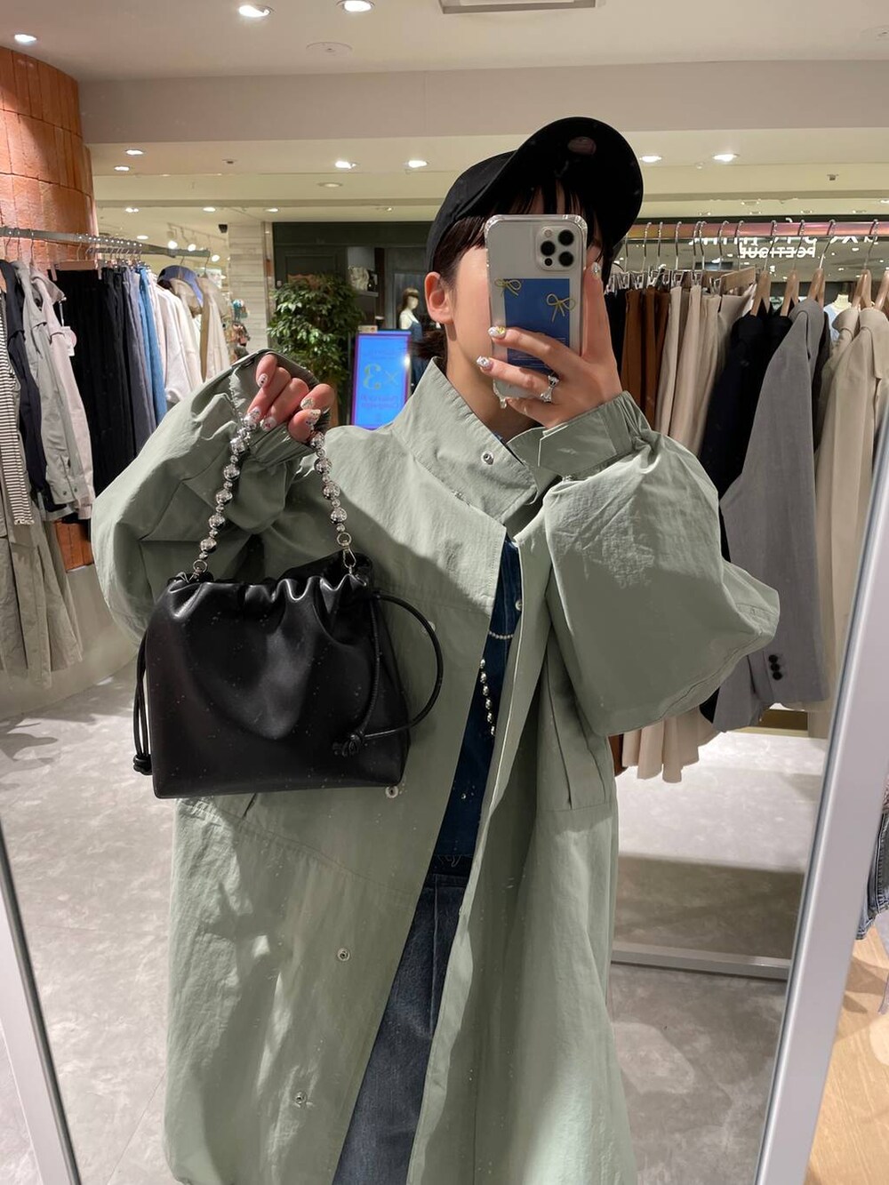 ブラック系のショルダーバッグ、ブルー系のデニムパンツ、ブルー系のシャツ/ブラウスを着用したレディースの春コーディネートの8枚目の写真