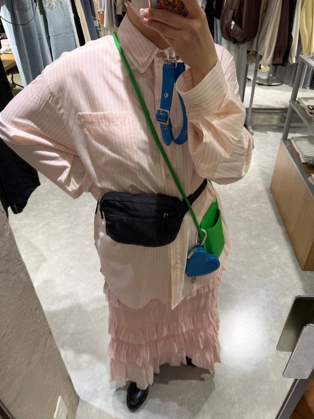 ブラック系のボディバッグ/ウエストポーチ、ブラック系のローファー、ピンク系のシャツ/ブラウスを着用したレディースの冬コーディネートの2枚目の写真