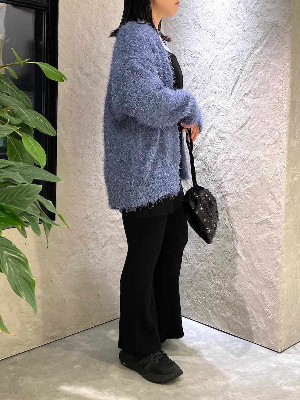 ブラック系のハンドバッグ、ホワイト系のTシャツ/カットソー、ブラック系のつなぎ/オールインワンを着用したレディースの冬コーディネートの4枚目の写真