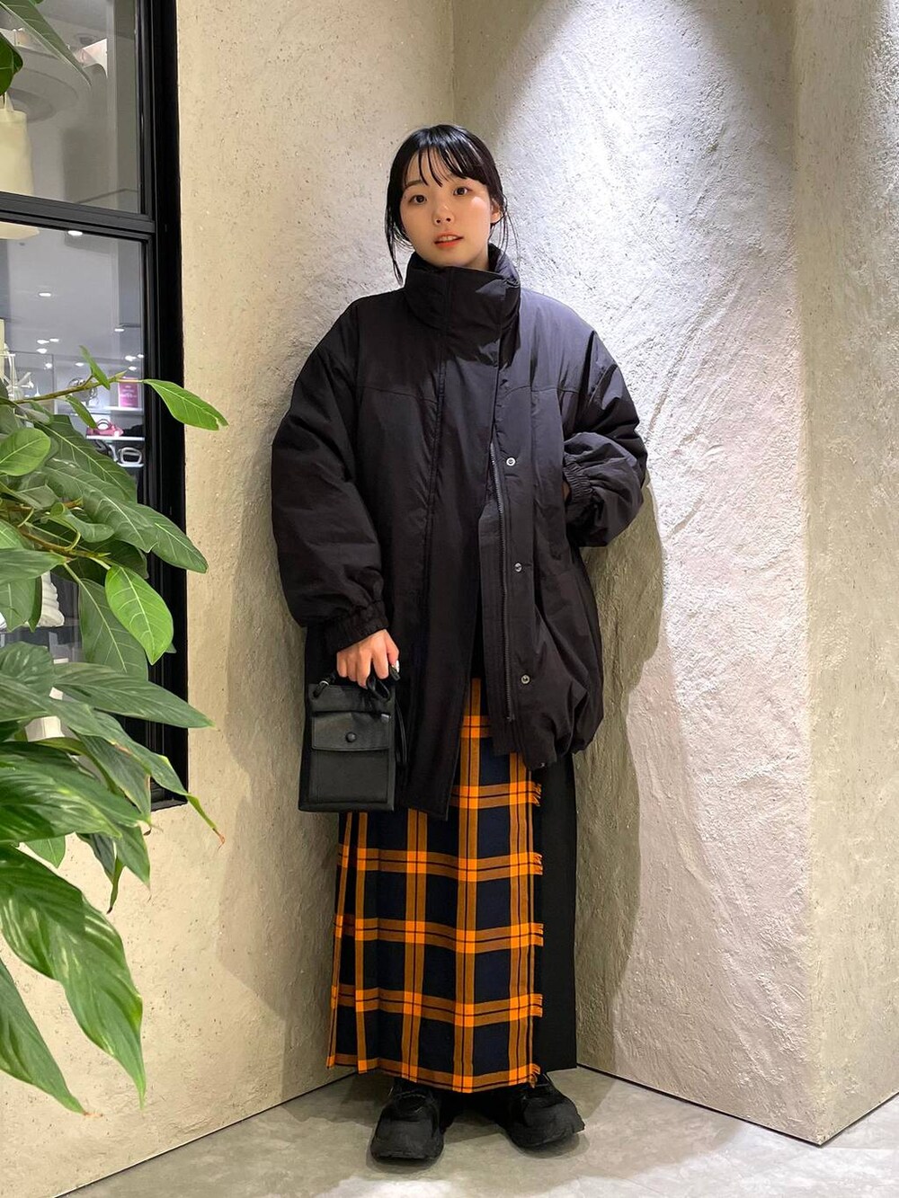 ブラック系のショルダーバッグ、ブラック系のダウンジャケット/コート、ブラック系のTシャツ/カットソーを着用したレディースの冬コーディネートの5枚目の写真