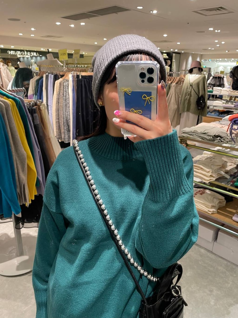 ブラック系のブーツ、ブルー系のその他パンツ、グリーン系のニット/セーターを着用したレディースの冬コーディネートの2枚目の写真