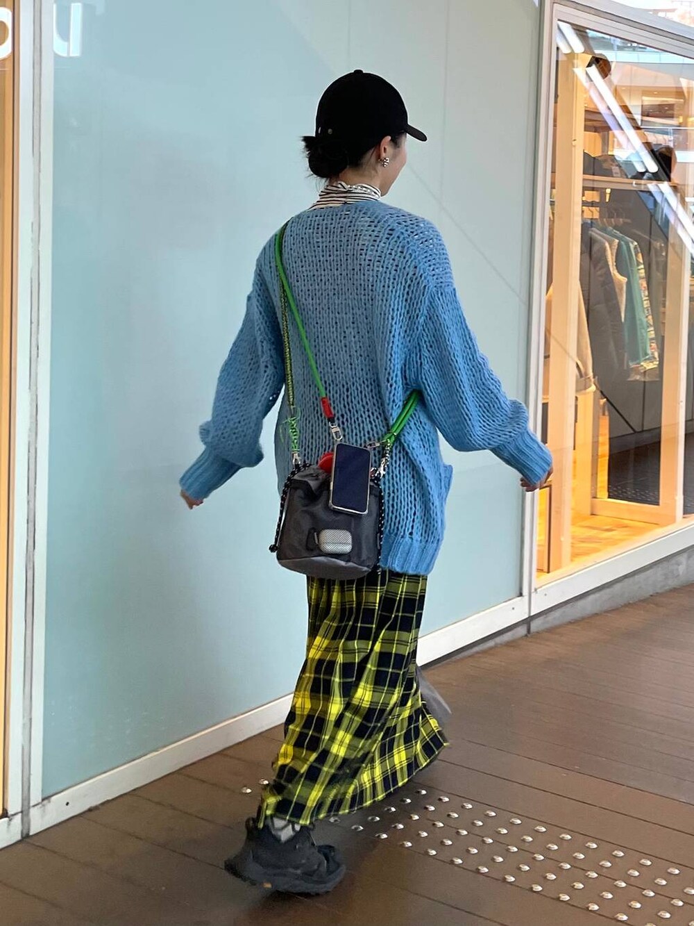 ホワイト系のTシャツ/カットソー、イエロー系のスカート、ブルー系のカーディガン/ボレロを着用したレディースの春コーディネートの4枚目の写真