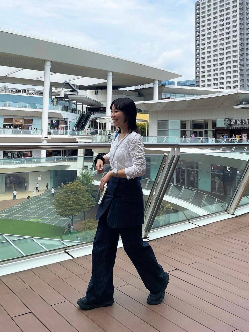 ブルー系のスラックス、その他のイヤリング、シルバー系のリングを着用したレディースの秋コーディネートの2枚目の写真