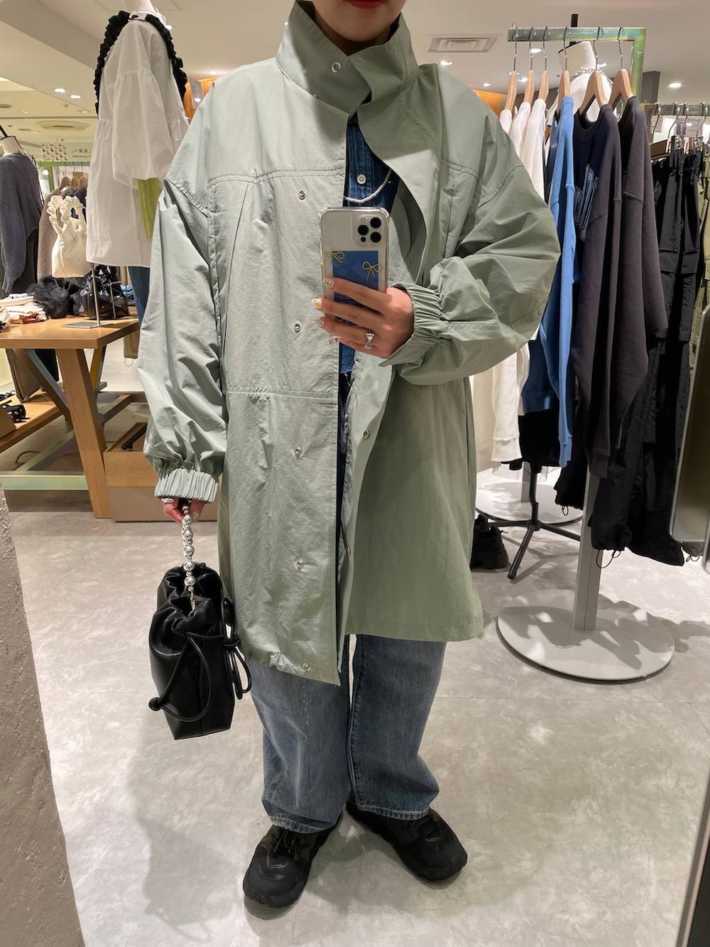 ブラック系のショルダーバッグ、ブルー系のデニムパンツ、ブルー系のシャツ/ブラウスを着用したレディースの春コーディネートの7枚目の写真