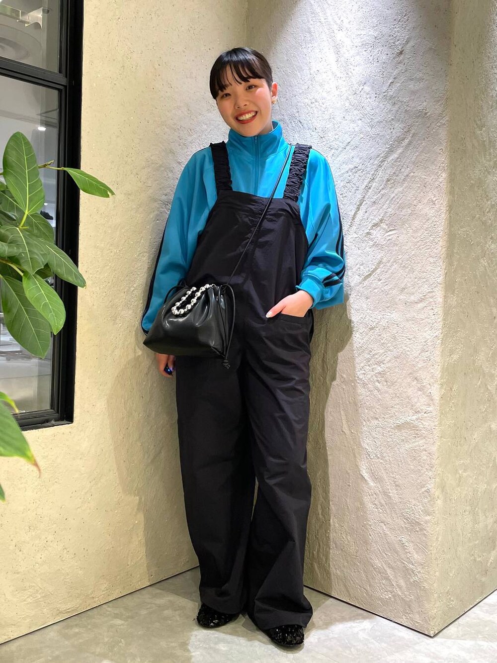 ブラック系のショルダーバッグ、ブルー系のサロペット/オーバーオール、ブルー系のTシャツ/カットソーを着用したレディースの春コーディネートの3枚目の写真