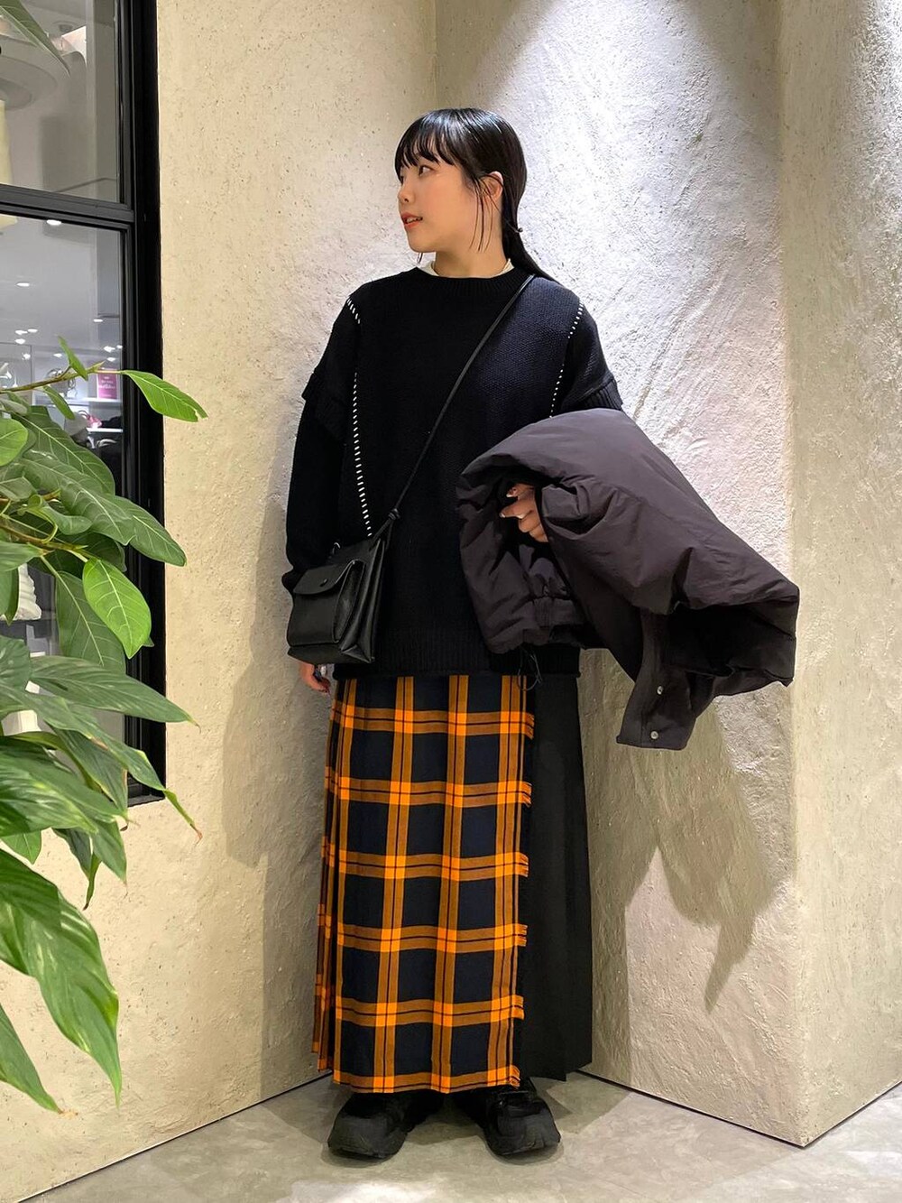 ブラック系のショルダーバッグ、ブラック系のダウンジャケット/コート、ブラック系のTシャツ/カットソーを着用したレディースの冬コーディネートの6枚目の写真