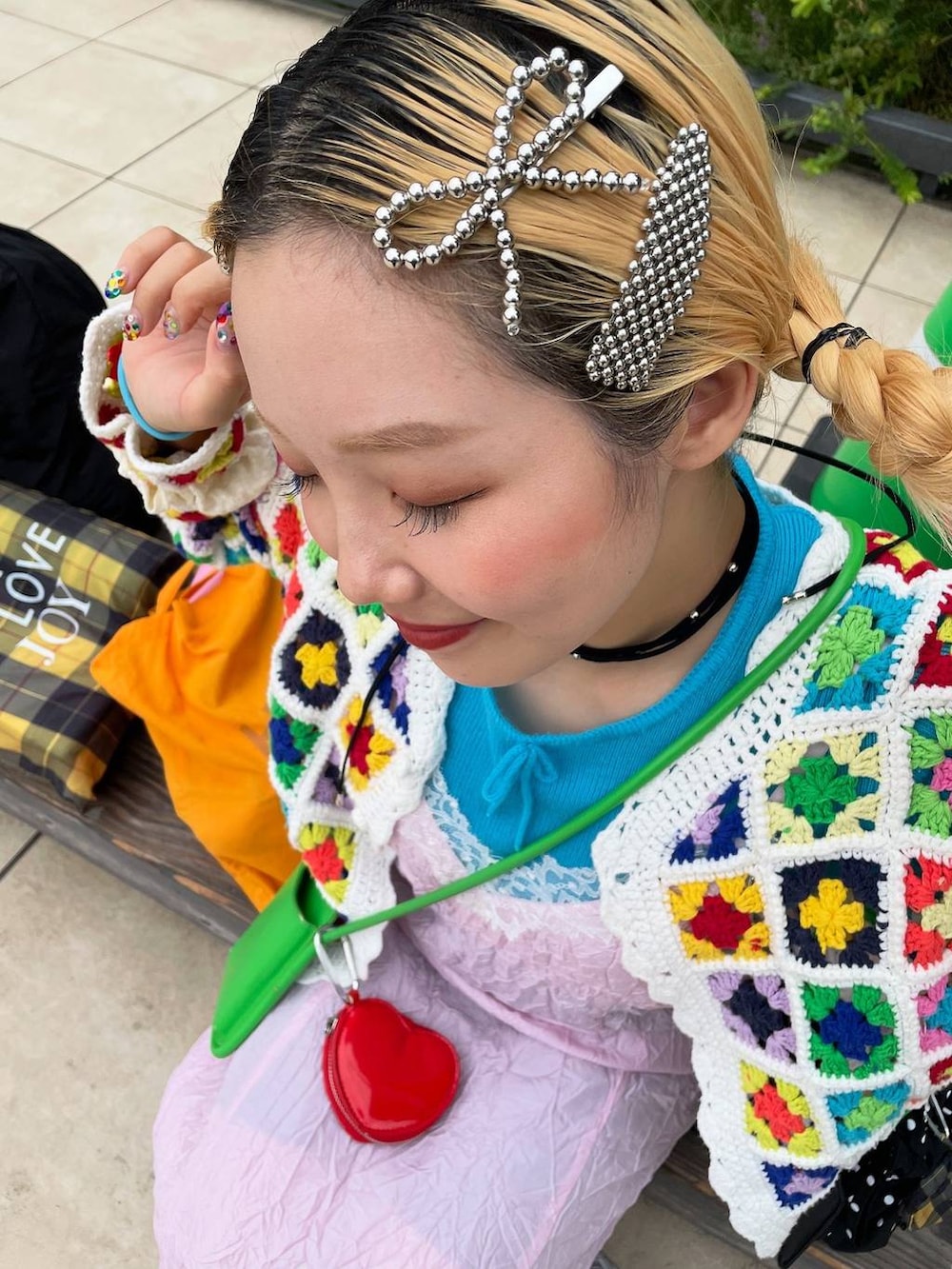 ブラック系のショルダーバッグ、グレー系のヘアピン、ブラック系のネックレスを着用したレディースの秋コーディネートの2枚目の写真