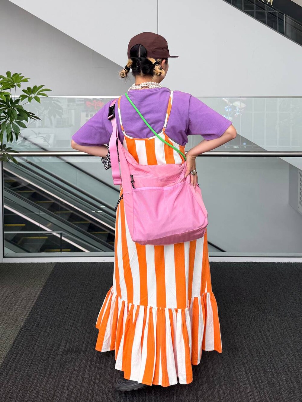 ピンク系のショルダーバッグ、ベージュ系のネックレス、ブラック系のシュシュを着用したレディースの夏コーディネートの5枚目の写真
