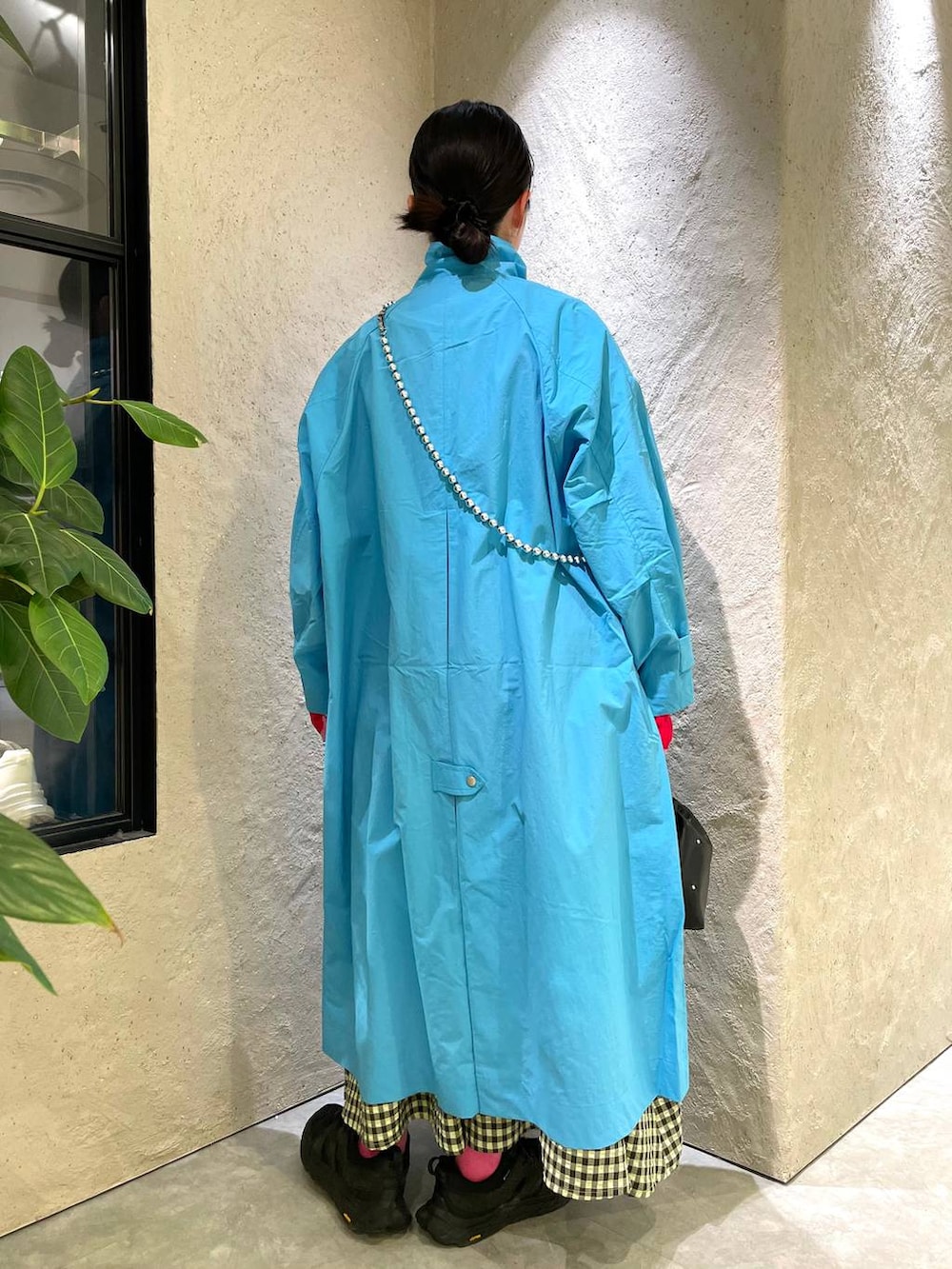 ブラック系のハンドバッグ、グリーン系のワンピース、ブルー系のブルゾンを着用したレディースの春コーディネートの3枚目の写真