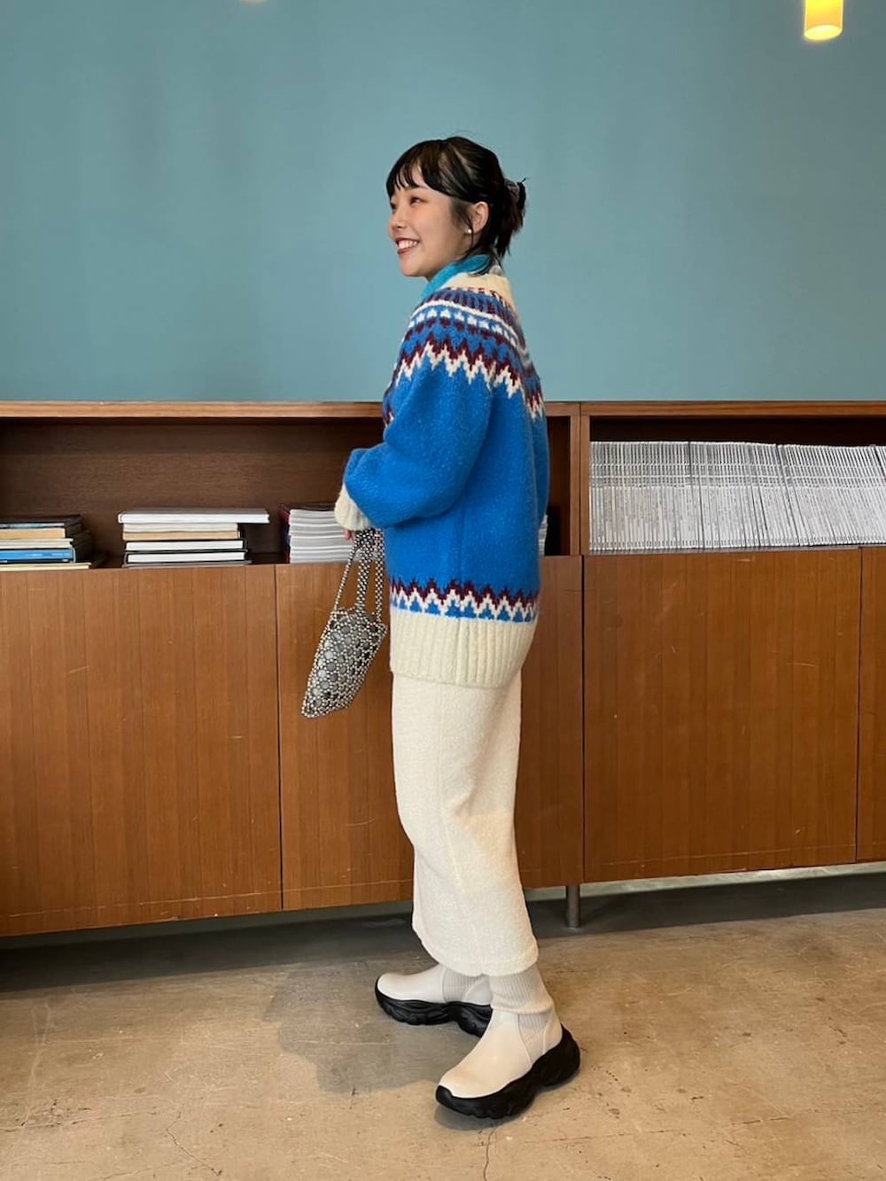 ホワイト系のスカート、シルバー系のショルダーバッグ、ブルー系のTシャツ/カットソーを着用したレディースの秋コーディネートの2枚目の写真