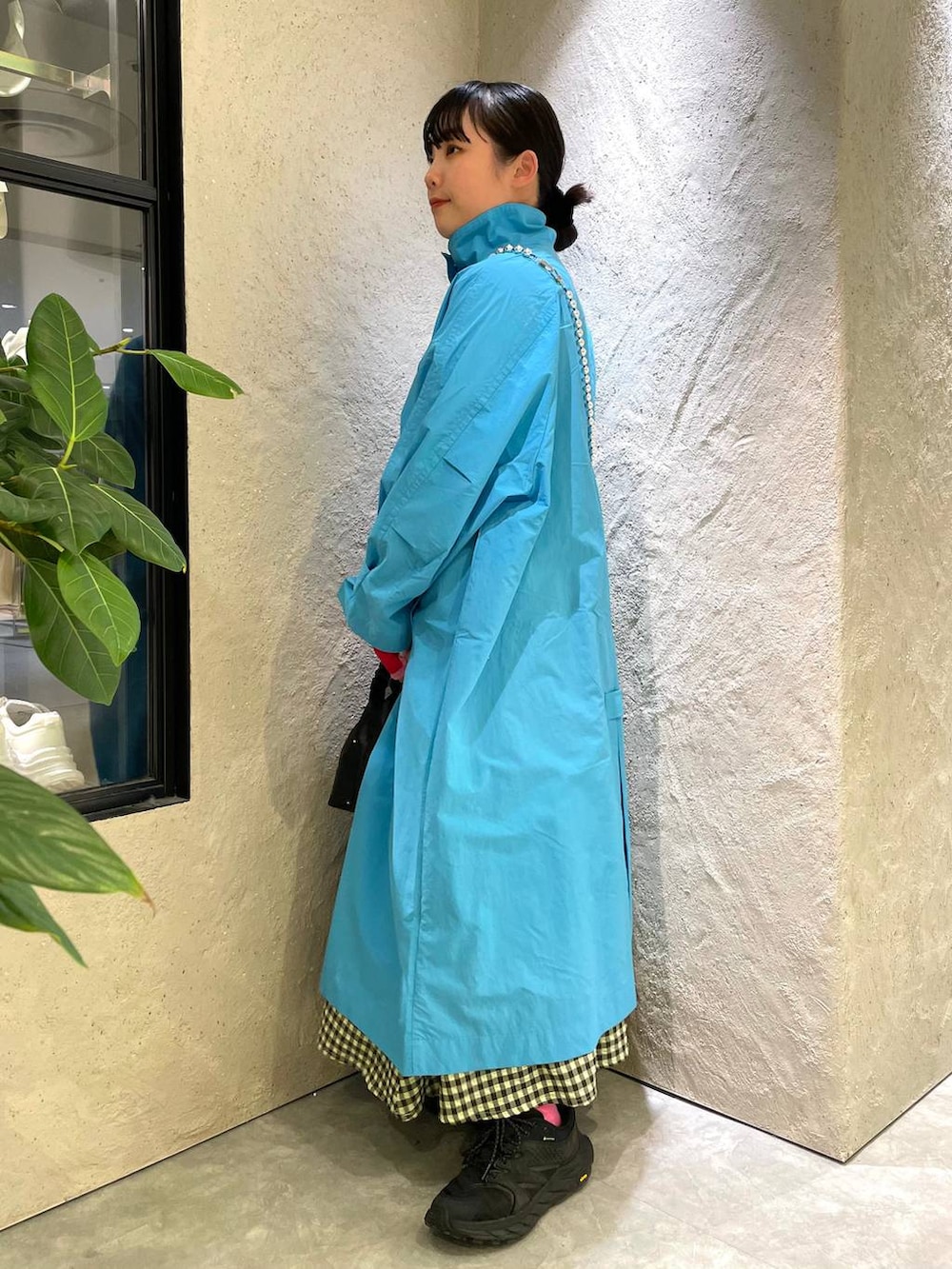 ブラック系のハンドバッグ、グリーン系のワンピース、ブルー系のブルゾンを着用したレディースの春コーディネートの2枚目の写真