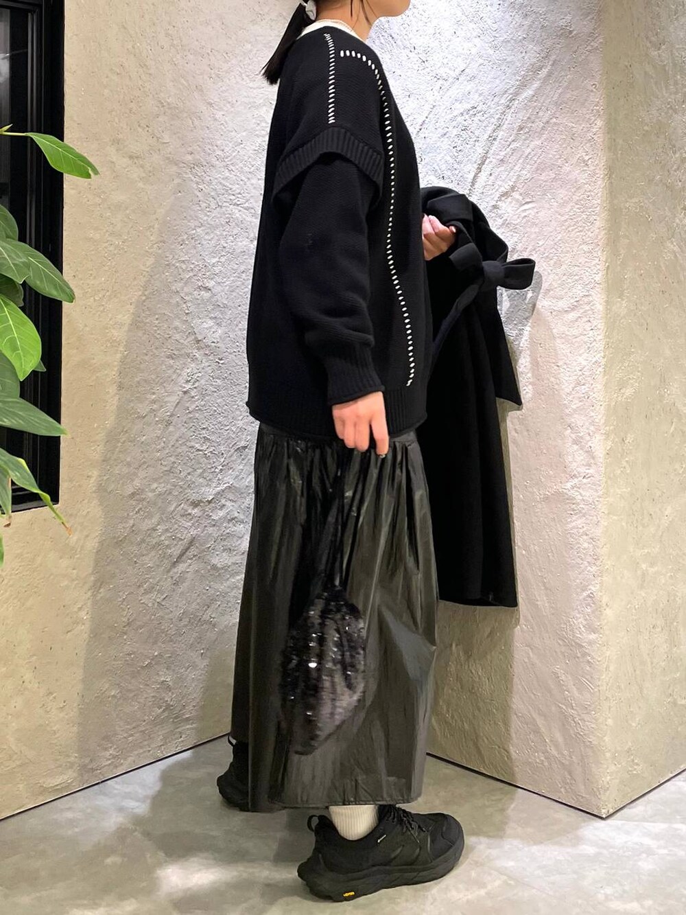 ブラック系のトレンチコート、ブラック系のTシャツ/カットソー、ブラック系のハンドバッグを着用したレディースの冬コーディネートの4枚目の写真