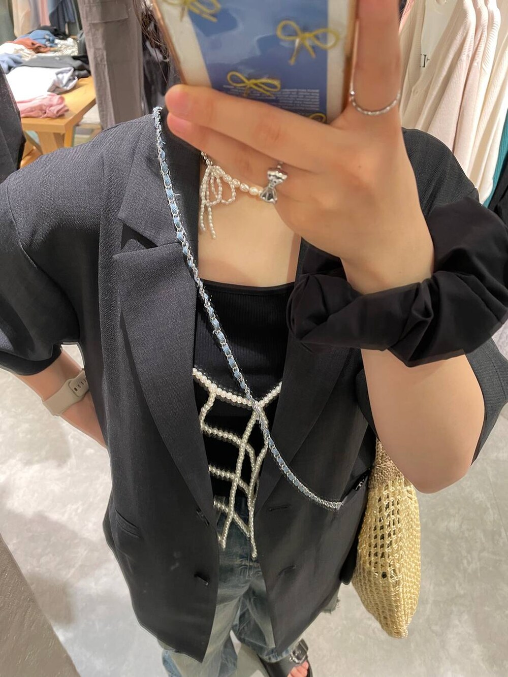 ベージュ系のショルダーバッグ、ブラック系のTシャツ/カットソー、ブルー系のデニムパンツを着用したレディースの夏コーディネートの7枚目の写真