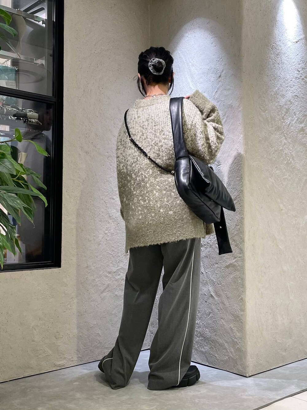 ブラック系のブーツ、グレー系のその他パンツ、グリーン系のニット/セーターを着用したレディースの秋コーディネートの4枚目の写真