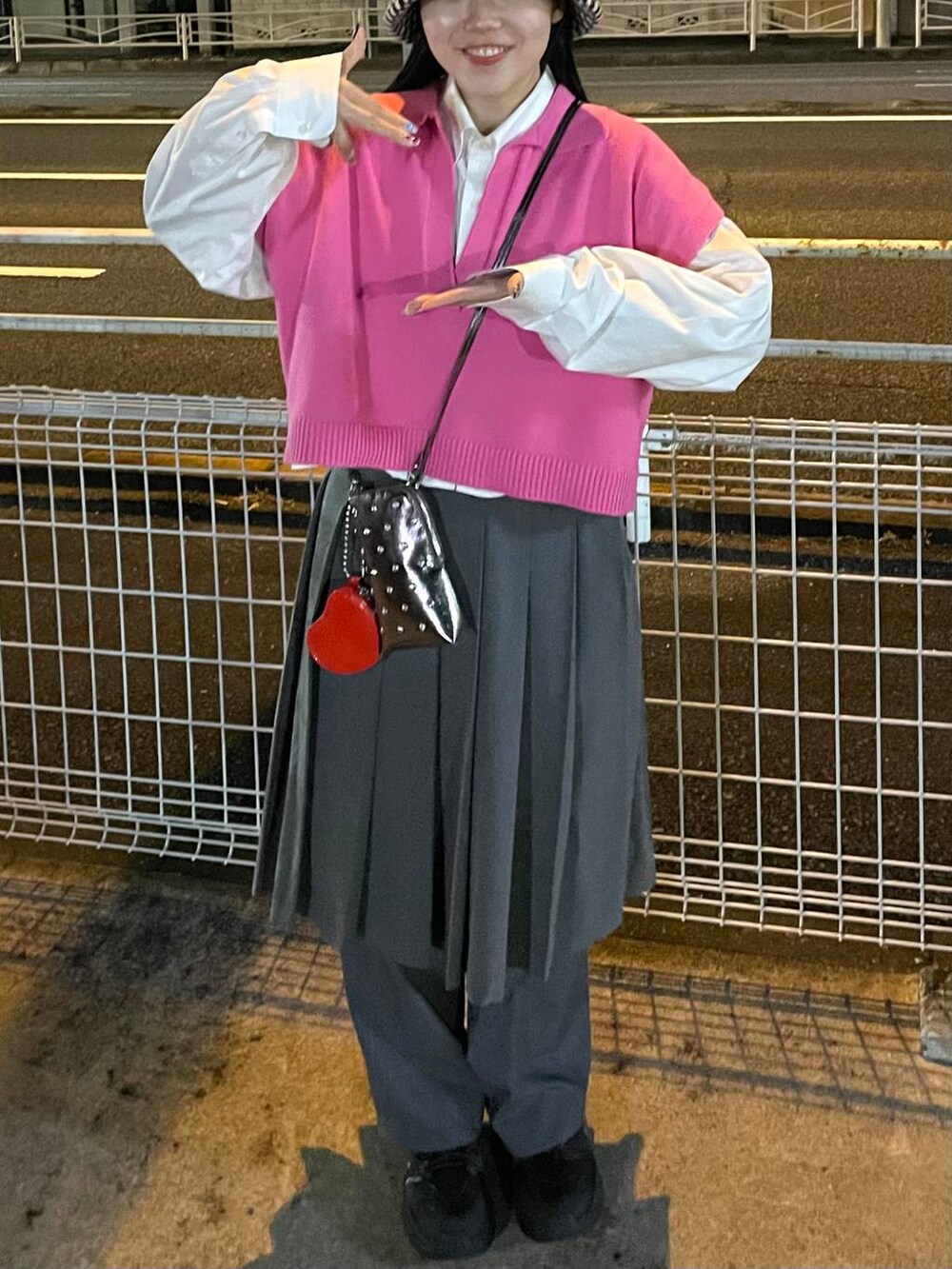 ピンク系のベスト、グレー系のスカートを着用したレディースの冬コーディネートの3枚目の写真