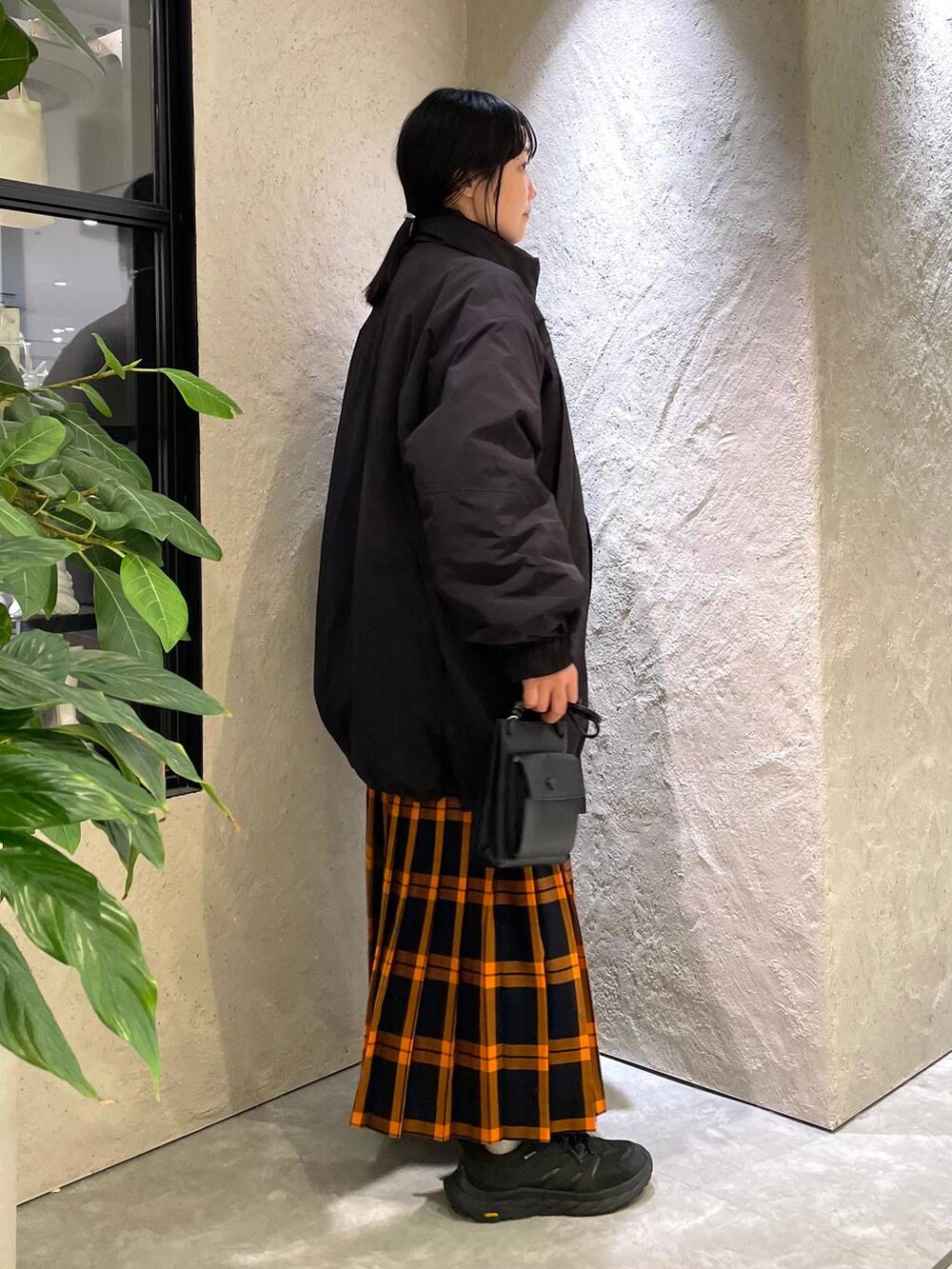 ブラック系のショルダーバッグ、ブラック系のダウンジャケット/コート、ブラック系のTシャツ/カットソーを着用したレディースの冬コーディネートの4枚目の写真