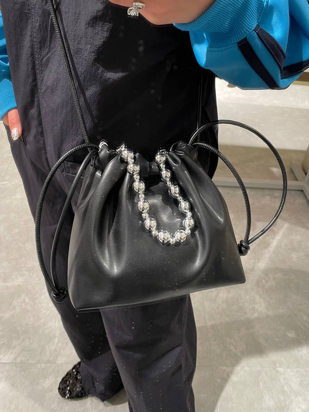 ブラック系のショルダーバッグ、ブルー系のサロペット/オーバーオール、ブルー系のTシャツ/カットソーを着用したレディースの春コーディネートの8枚目の写真