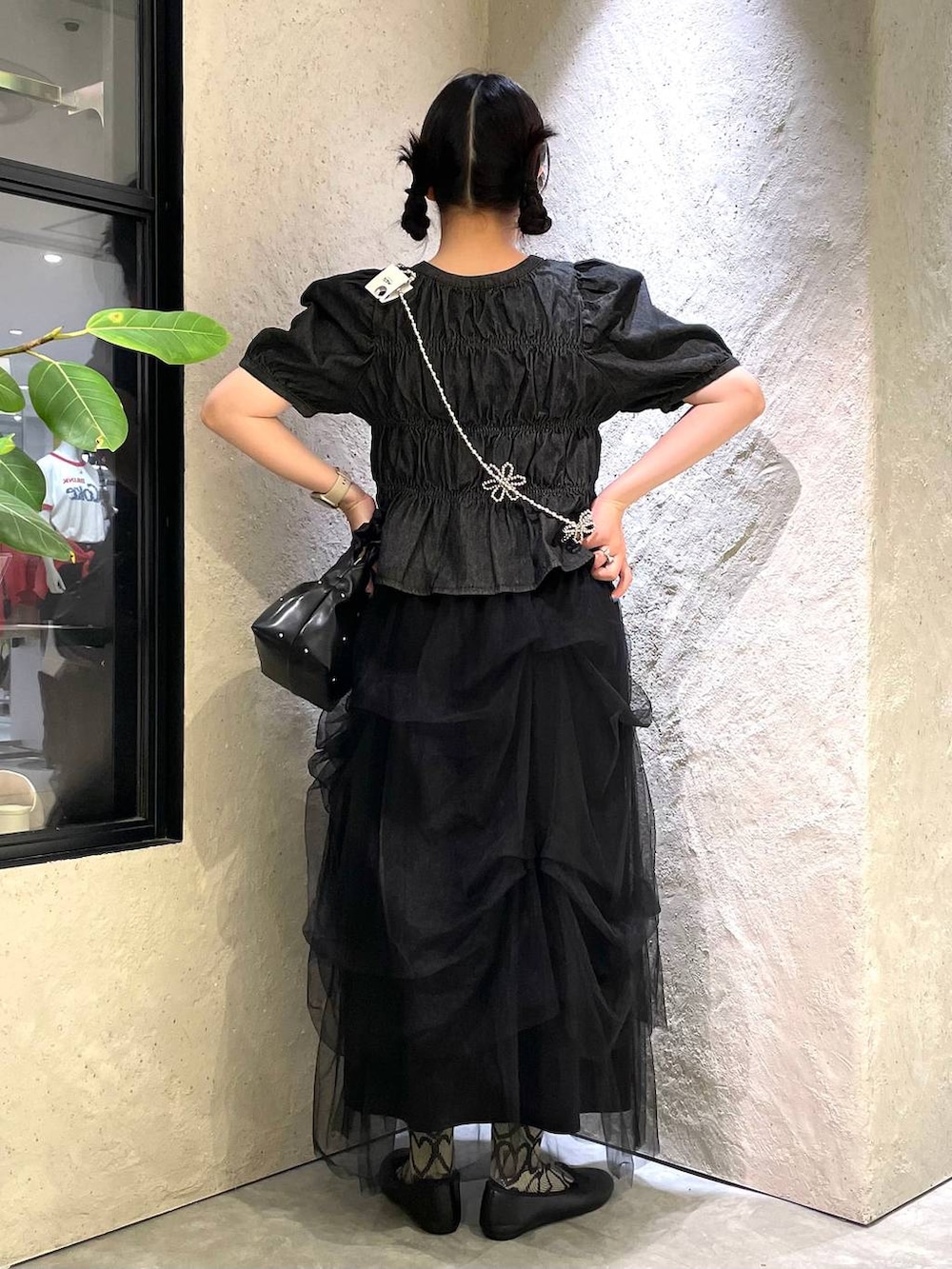 ブラック系のハンドバッグ、ブルー系のタンクトップ、ブラック系のバレエシューズを着用したレディースの春コーディネートの4枚目の写真