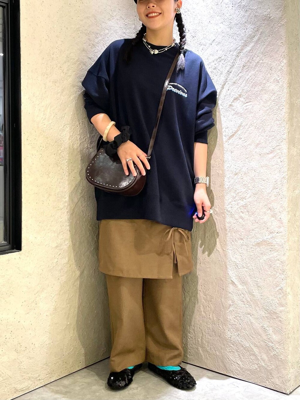 ブラウン系のショルダーバッグ、ブルー系のスウェット、ブラック系のバレエシューズを着用したレディースの秋コーディネートの2枚目の写真