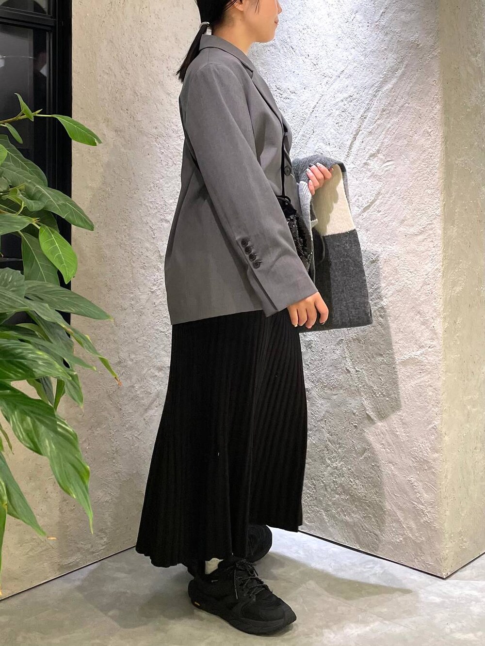 ブラック系のハンドバッグ、ブラック系のワンピース、ホワイト系のTシャツ/カットソーを着用したレディースの冬コーディネートの4枚目の写真