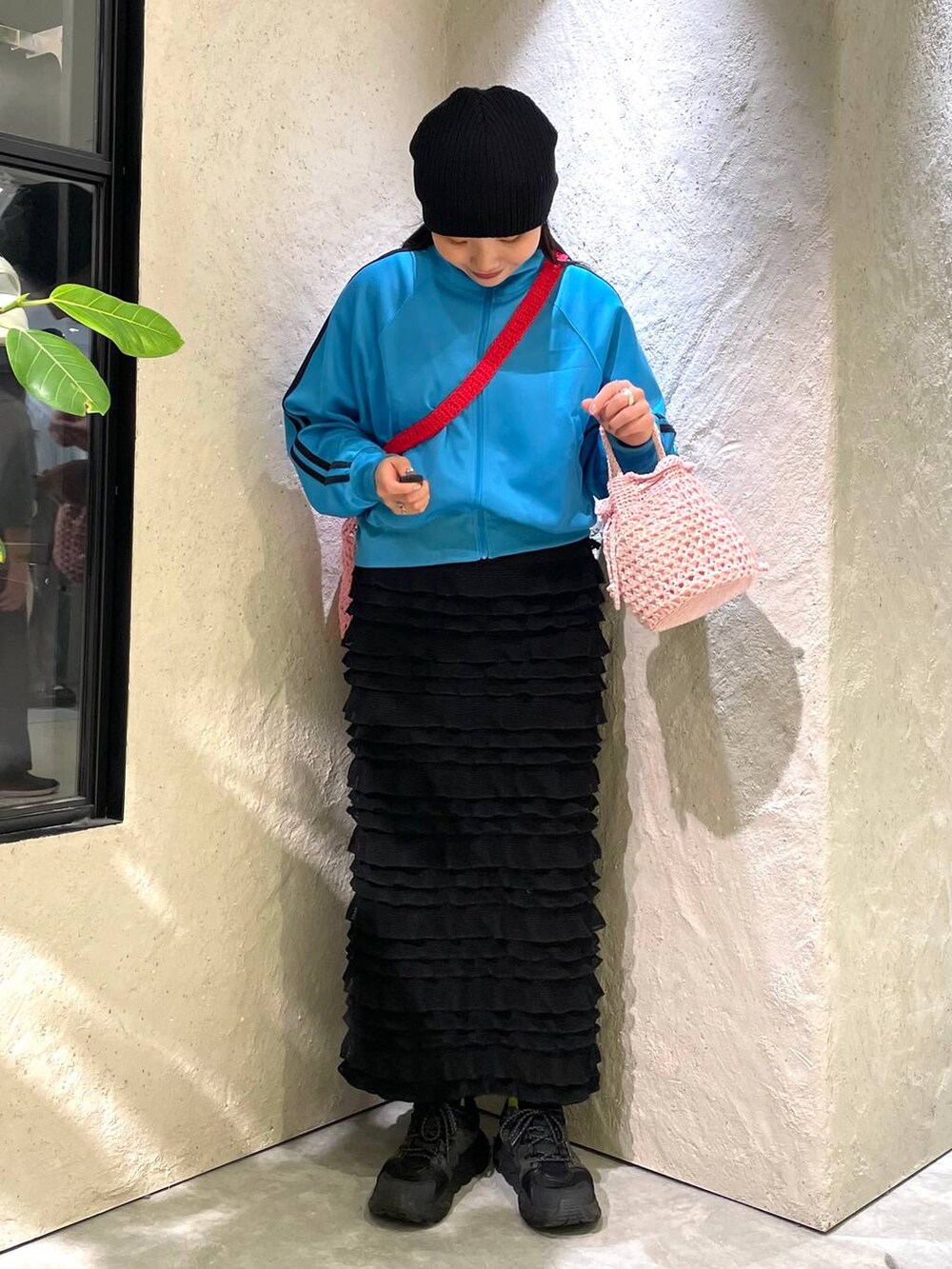 ピンク系のショルダーバッグ、ブルー系のTシャツ/カットソー、ブラック系のスカートを着用したレディースの春コーディネートの3枚目の写真