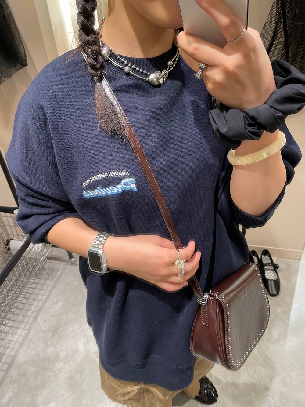 ブラウン系のショルダーバッグ、ブルー系のスウェット、ブラック系のバレエシューズを着用したレディースの秋コーディネートの6枚目の写真