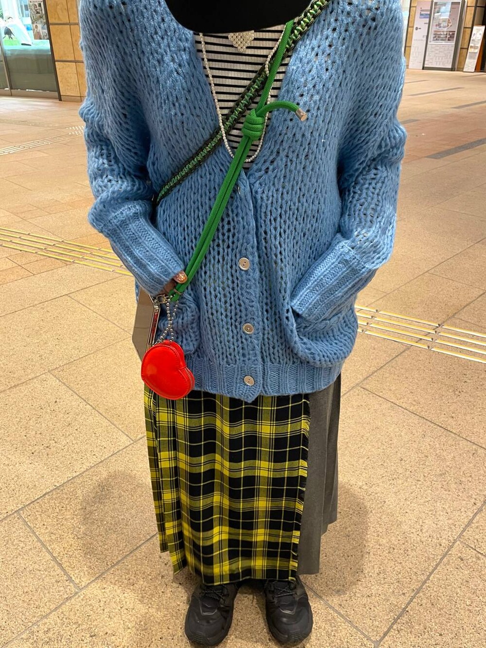 ホワイト系のTシャツ/カットソー、イエロー系のスカート、ブルー系のカーディガン/ボレロを着用したレディースの春コーディネートの6枚目の写真