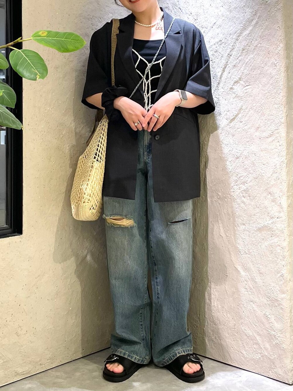 ベージュ系のショルダーバッグ、ブラック系のTシャツ/カットソー、ブルー系のデニムパンツを着用したレディースの夏コーディネートの6枚目の写真
