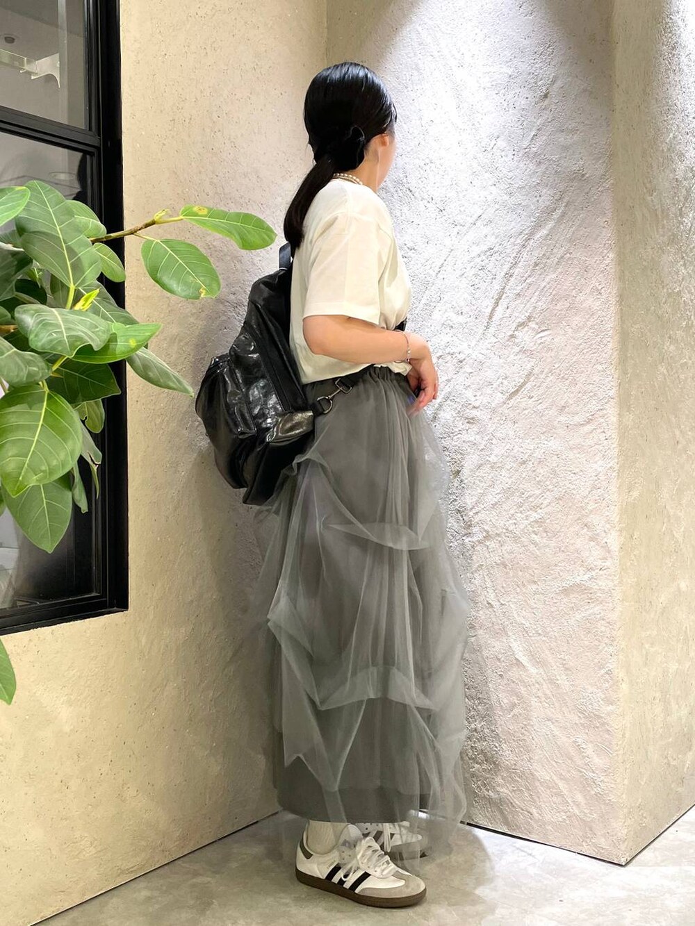 グレー系のスカート、ホワイト系のTシャツ/カットソー、ブラック系のショルダーバッグを着用したレディースの夏コーディネートの5枚目の写真