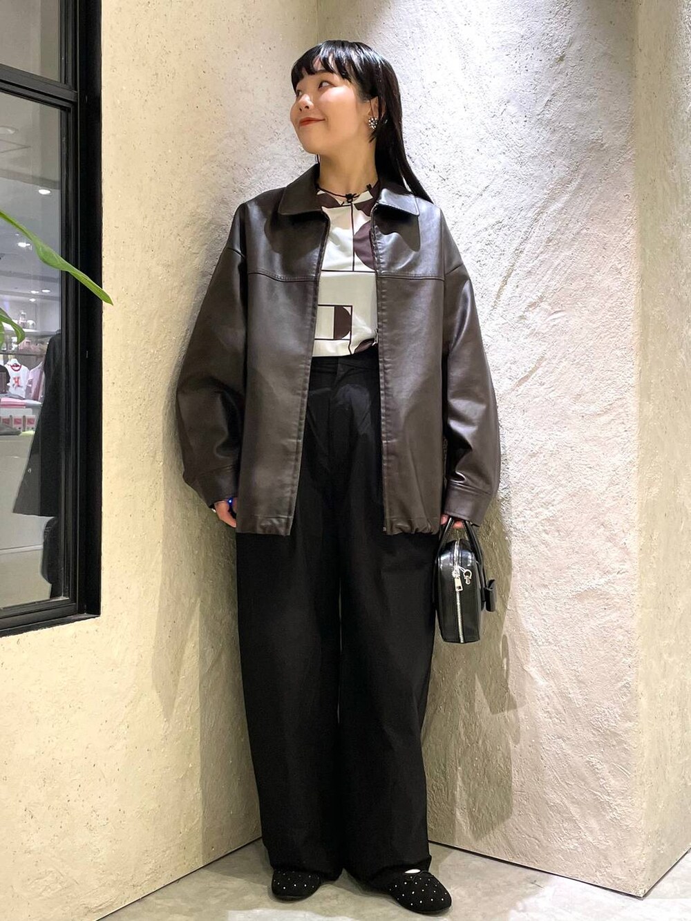 ブラウン系のブルゾン、ブラック系のバレエシューズ、ブラック系のボストンバッグを着用したレディースの秋コーディネートの2枚目の写真