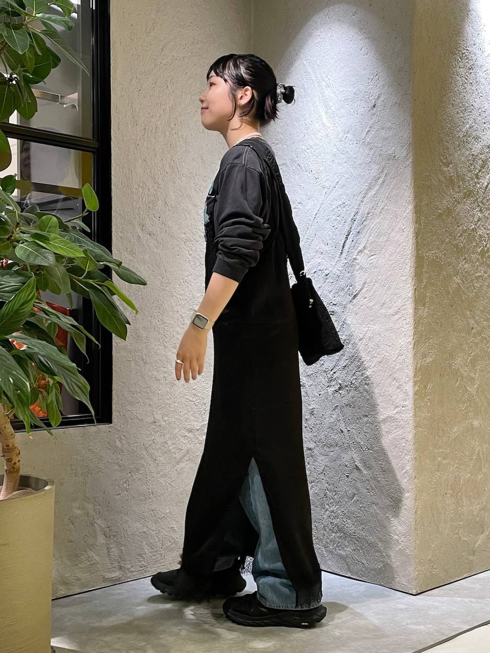 ブルー系のデニムパンツ、グレー系のTシャツ/カットソー、ブラック系のワンピースを着用したレディースの秋コーディネートの2枚目の写真