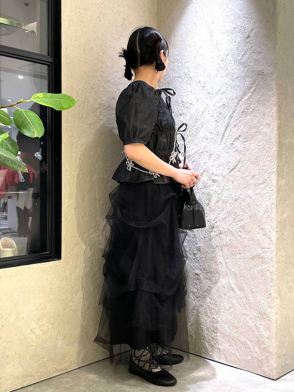 ブラック系のハンドバッグ、ブルー系のタンクトップ、ブラック系のバレエシューズを着用したレディースの春コーディネートの5枚目の写真