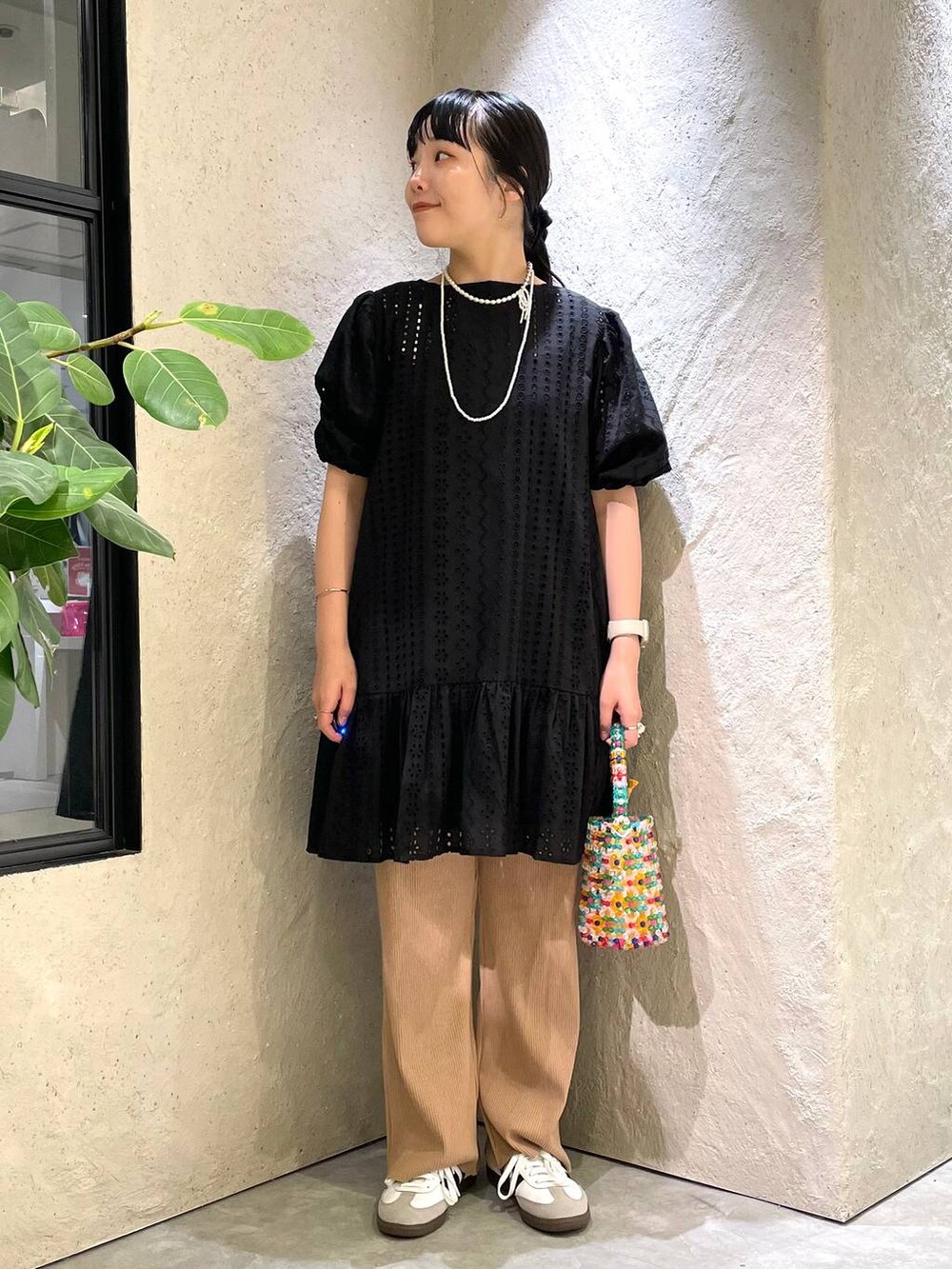 ホワイト系のスニーカー、ベージュ系のその他パンツ、その他のハンドバッグを着用したレディースの夏コーディネートの2枚目の写真