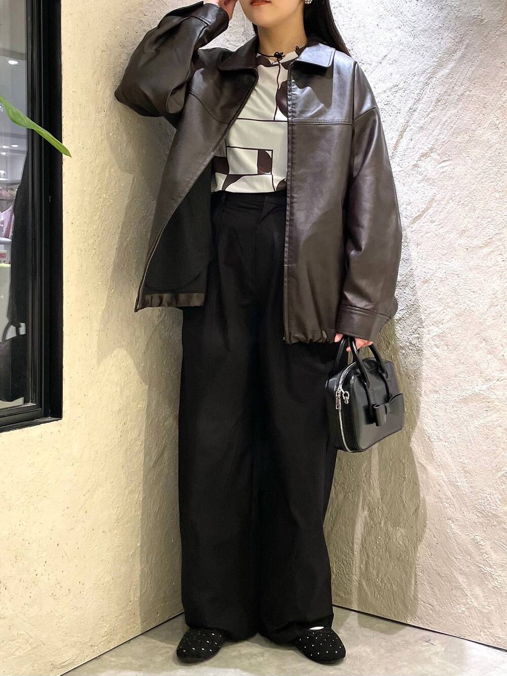 ブラウン系のブルゾン、ブラック系のバレエシューズ、ブラック系のボストンバッグを着用したレディースの秋コーディネートの3枚目の写真