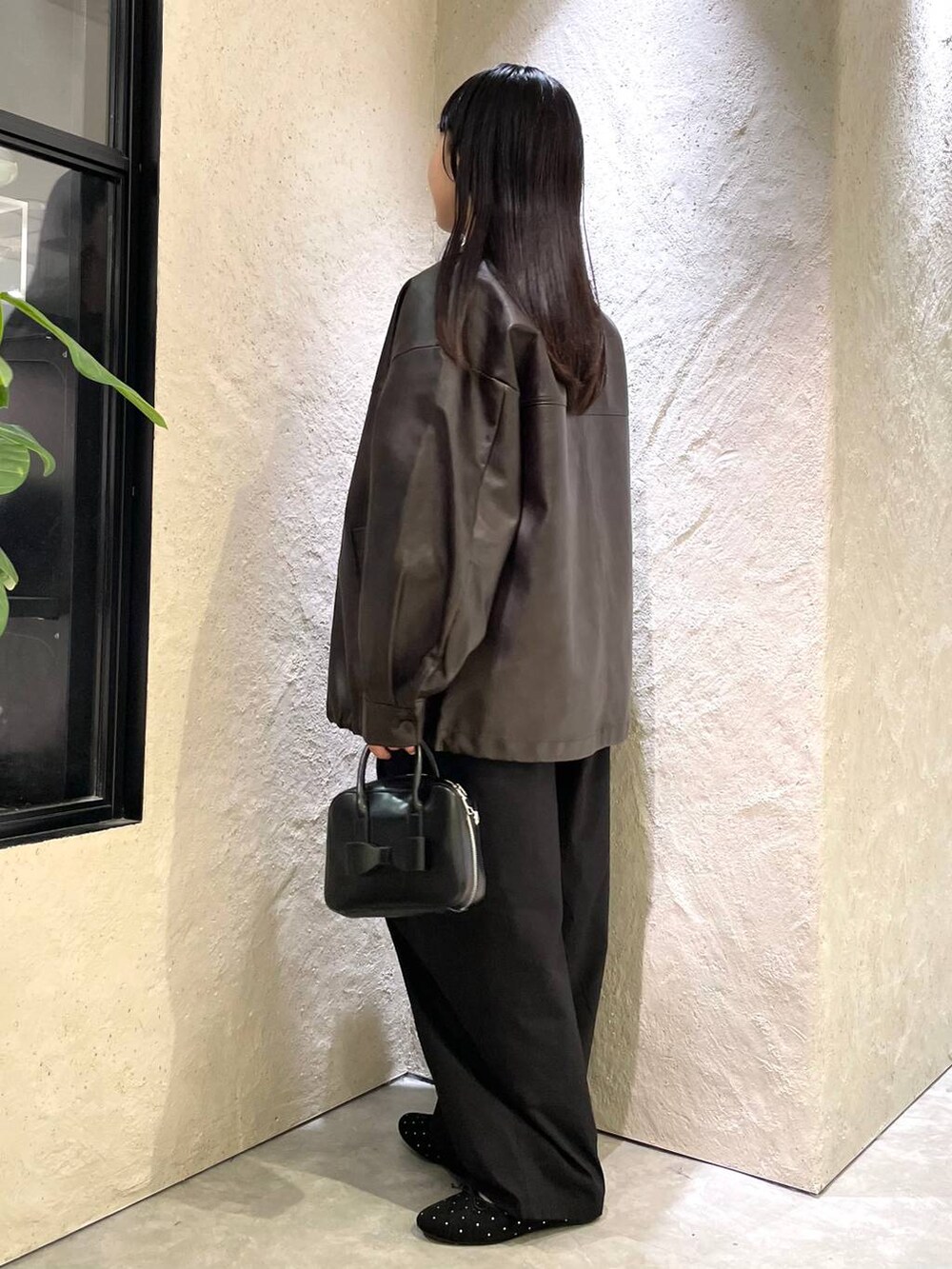 ブラウン系のブルゾン、ブラック系のバレエシューズ、ブラック系のボストンバッグを着用したレディースの秋コーディネートの4枚目の写真