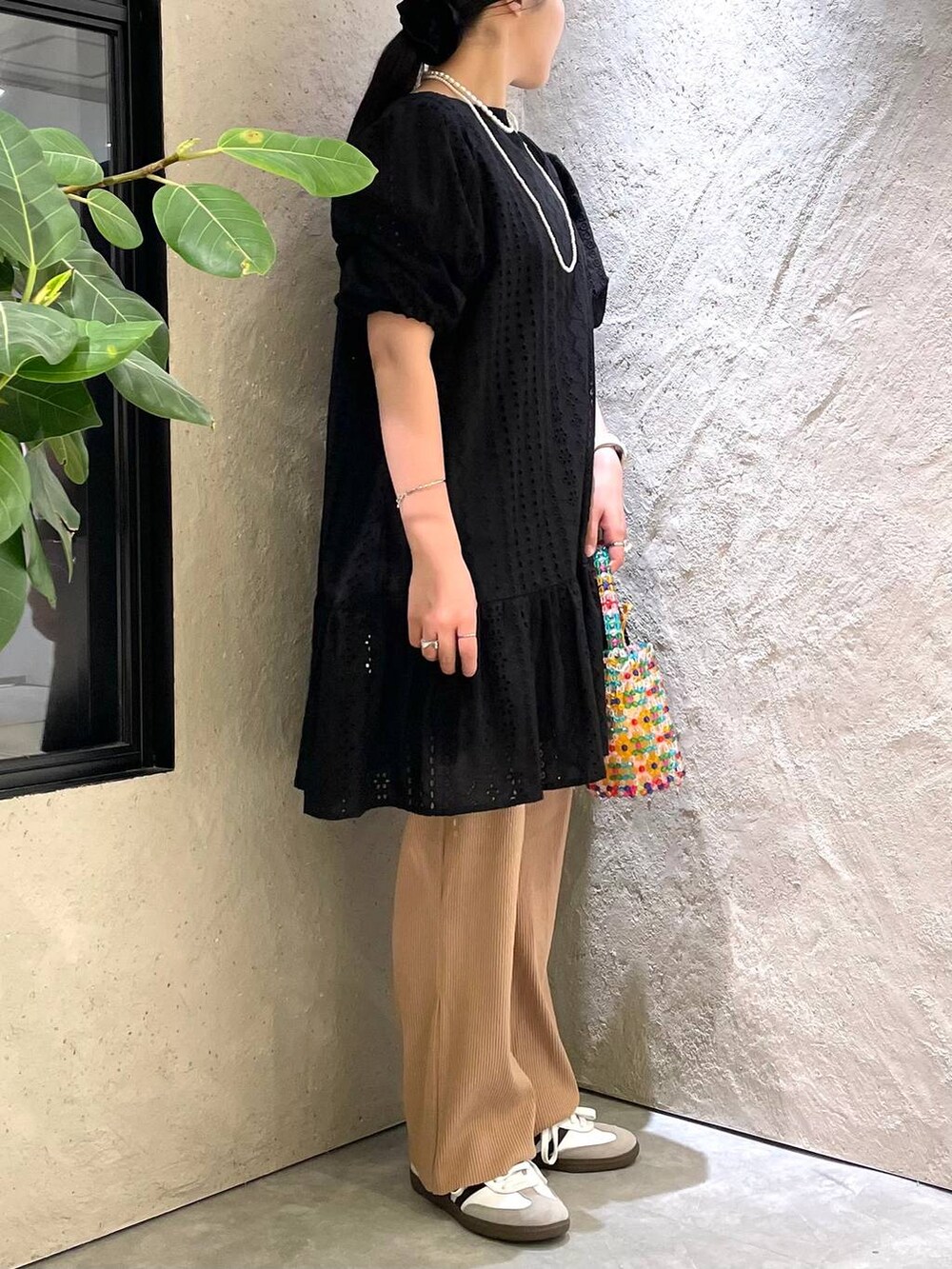 ホワイト系のスニーカー、ベージュ系のその他パンツ、その他のハンドバッグを着用したレディースの夏コーディネートの5枚目の写真