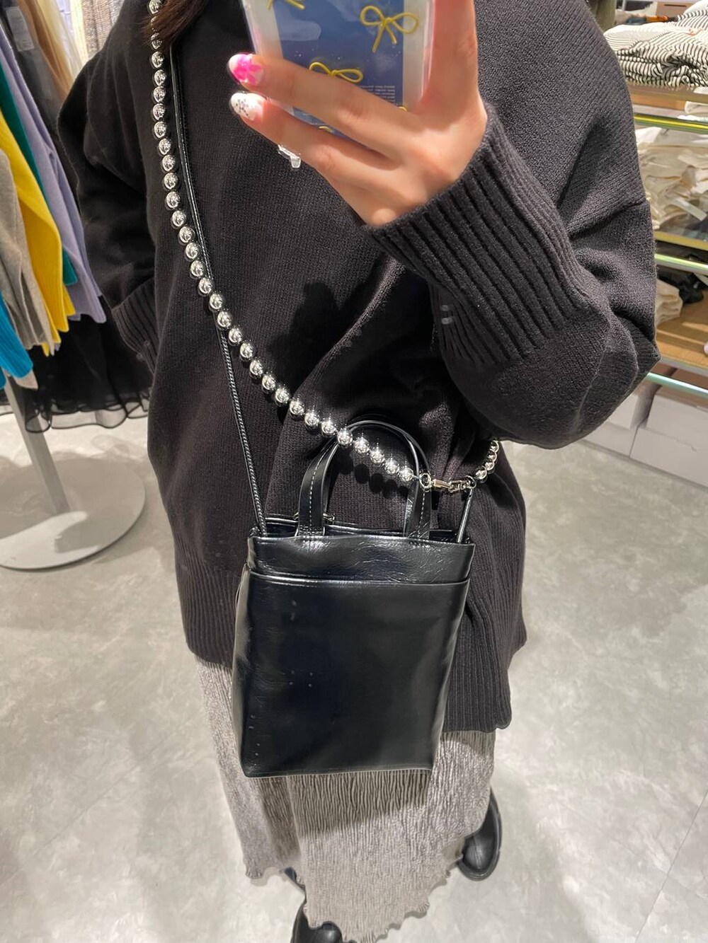 ブラック系のブーツ、ブルー系のその他パンツ、ブラック系のニット/セーターを着用したレディースの冬コーディネートの3枚目の写真