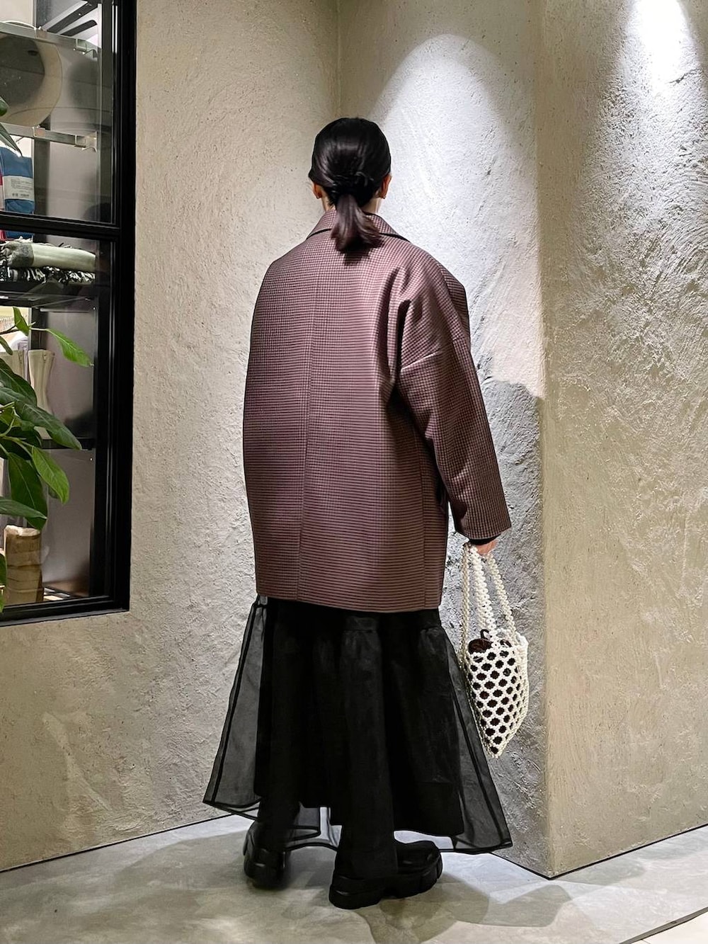 ブラック系のブーツ、ホワイト系のショルダーバッグ、ブラック系のニット/セーターを着用したレディースの秋コーディネートの3枚目の写真