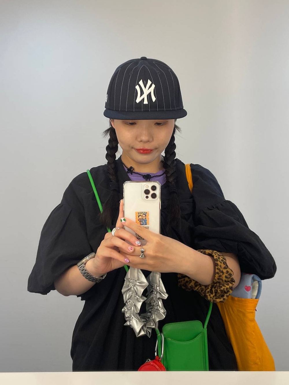 ブルー系のキャップ、シルバー系のスマホグッズ、ブラウン系のシュシュを着用したレディースの春コーディネートの2枚目の写真