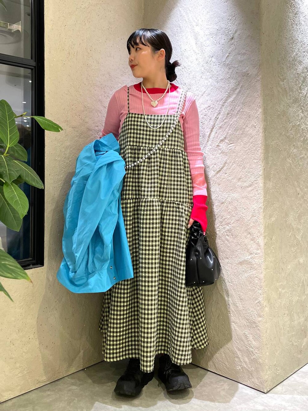 ブラック系のハンドバッグ、グリーン系のワンピース、ブルー系のブルゾンを着用したレディースの春コーディネートの6枚目の写真