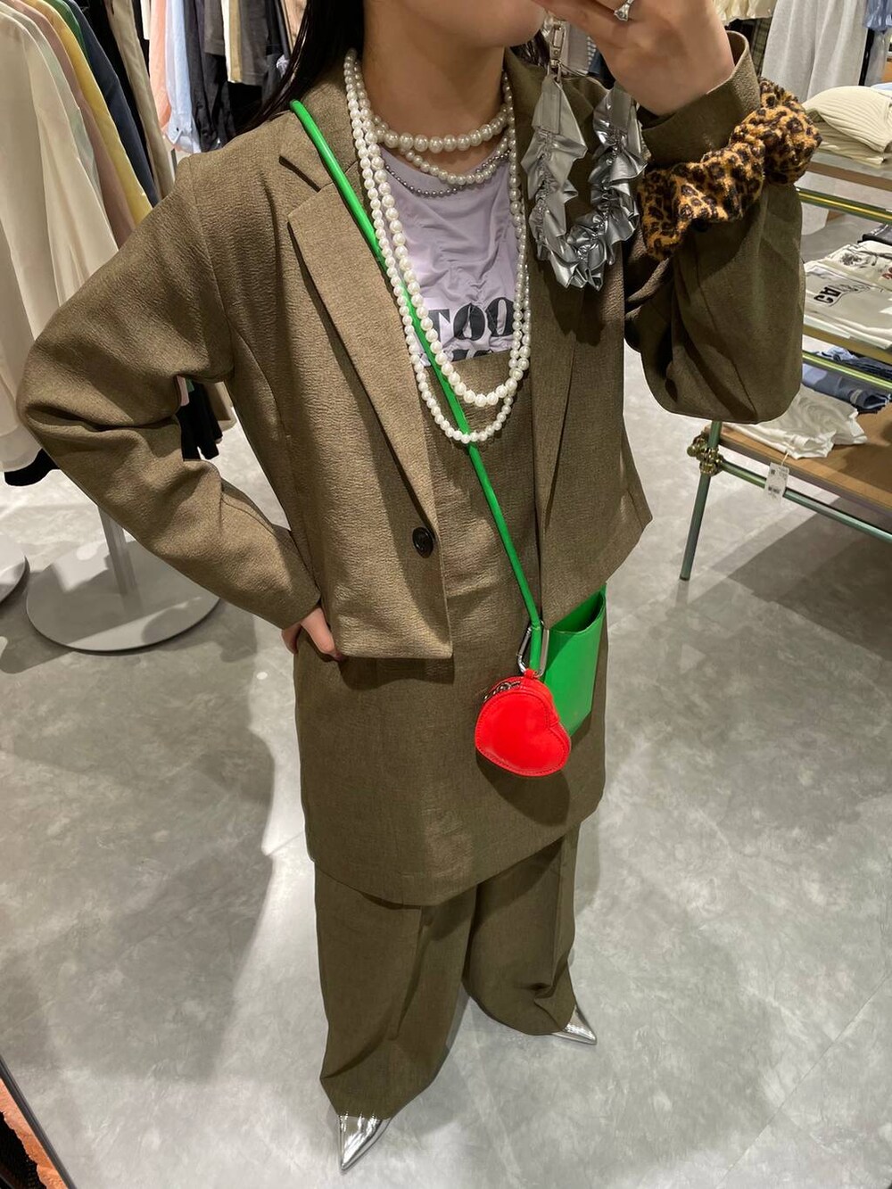 ブラウン系のスラックス、ブラウン系のテーラードジャケット、ブラウン系のキャミソールを着用したレディースの春コーディネートの7枚目の写真