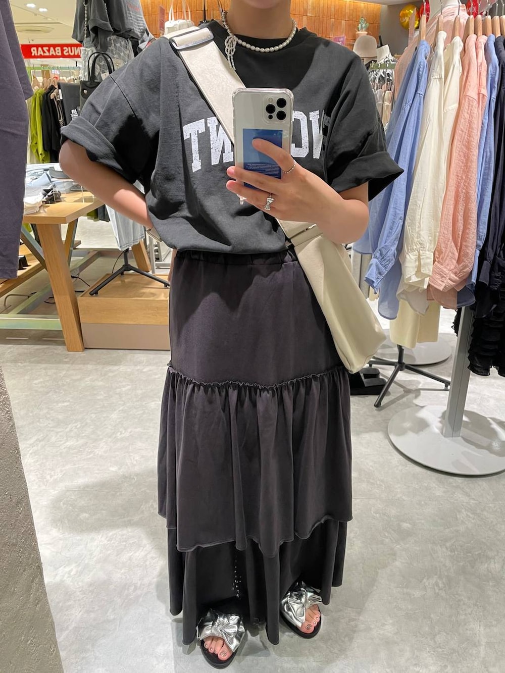 グレー系のTシャツ/カットソー、ホワイト系のボディバッグ/ウエストポーチ、シルバー系のサンダルを着用したレディースの夏コーディネートの6枚目の写真