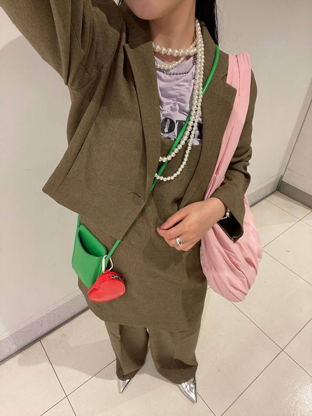 ブラウン系のスラックス、ブラウン系のテーラードジャケット、ブラウン系のキャミソールを着用したレディースの春コーディネートの6枚目の写真